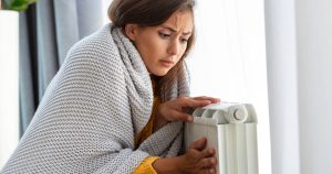 worried woman holding heater